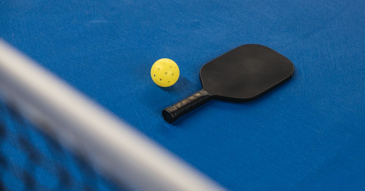 Pickleball ball and paddle on a court