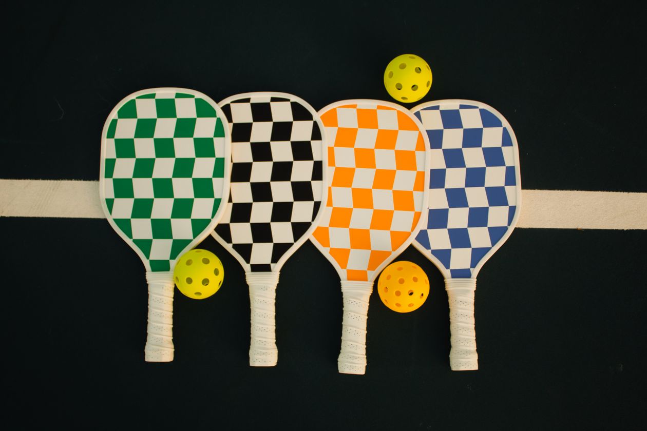 Pickleball paddles and gear laid out on a court, ready for packing