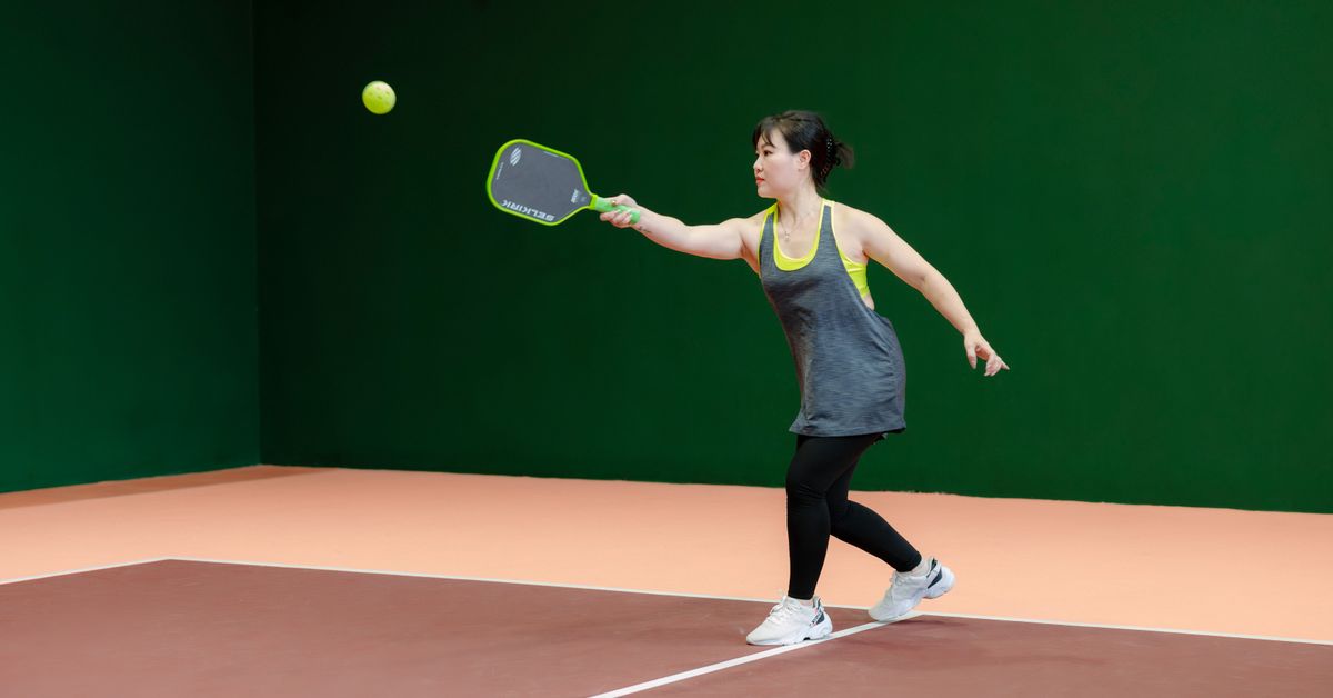 Woman playing pickleball on an indoor court