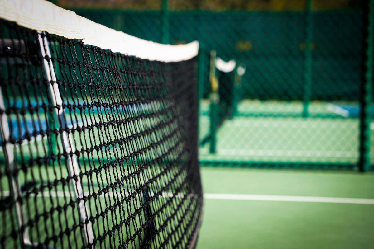 White net on a green pickleball court