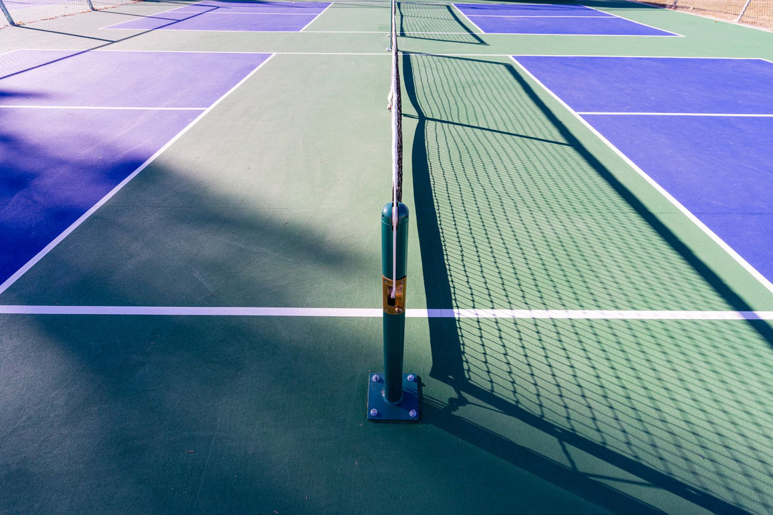 Empty pickleball court with net in summer sun