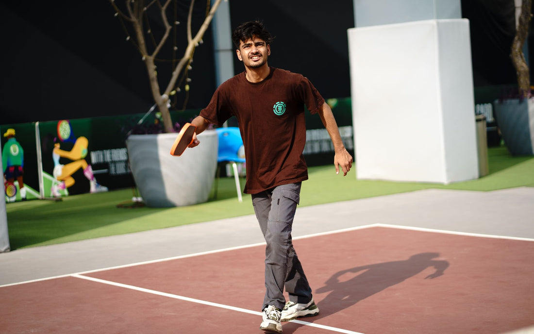 Young man playing pickleball on an outdoor court