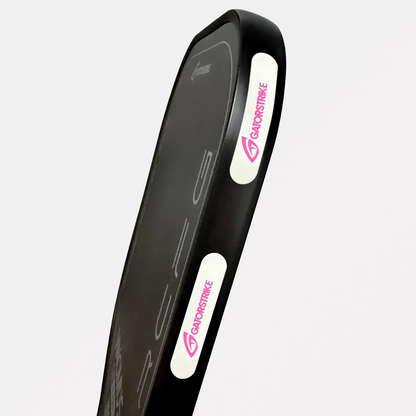 A black rectangular kick shield with white side panels, featuring the pink Gainorstrike logo and paddle resistance design.