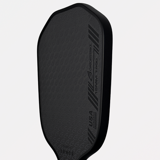 Close-up of a dark gray Gatorstrike pickleball paddle, textured surface, slanted stripes, and meets official pickleball rules.