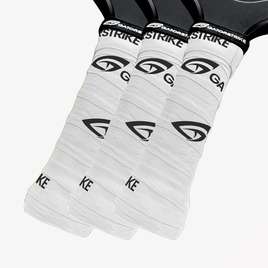 Three white Gatorstrike paddle covers with black logos, as seen in the official pickleball rules illustrations.