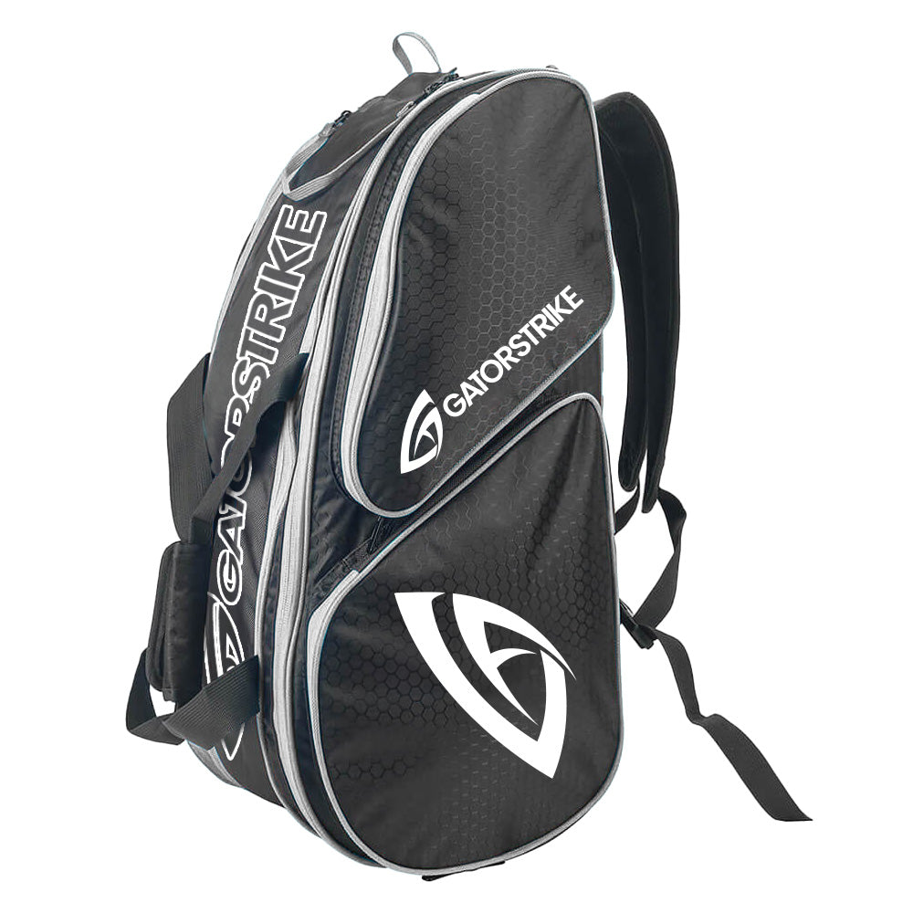 The GATORSTRIKE black and gray sports paddle bag features a honeycomb pattern, white logo and emblem, multiple zippered pockets, fits elongated paddles, and includes shoulder straps plus a carrying handle.